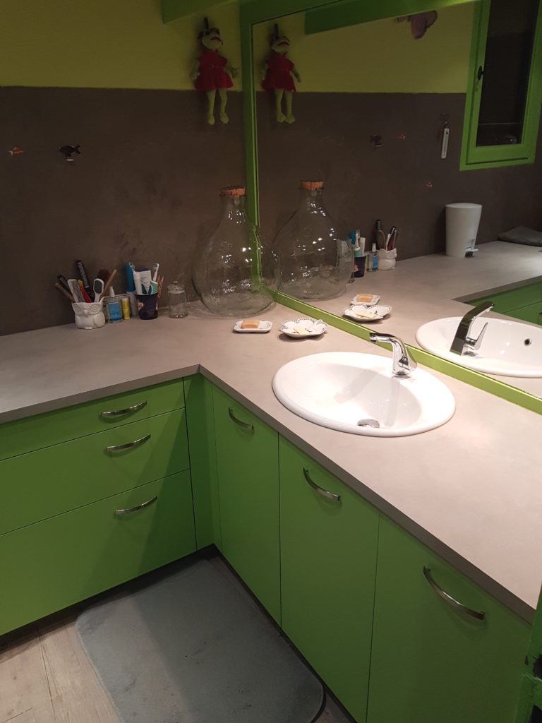 Mobilier de salle de bains verte et plan de travail couleur sable